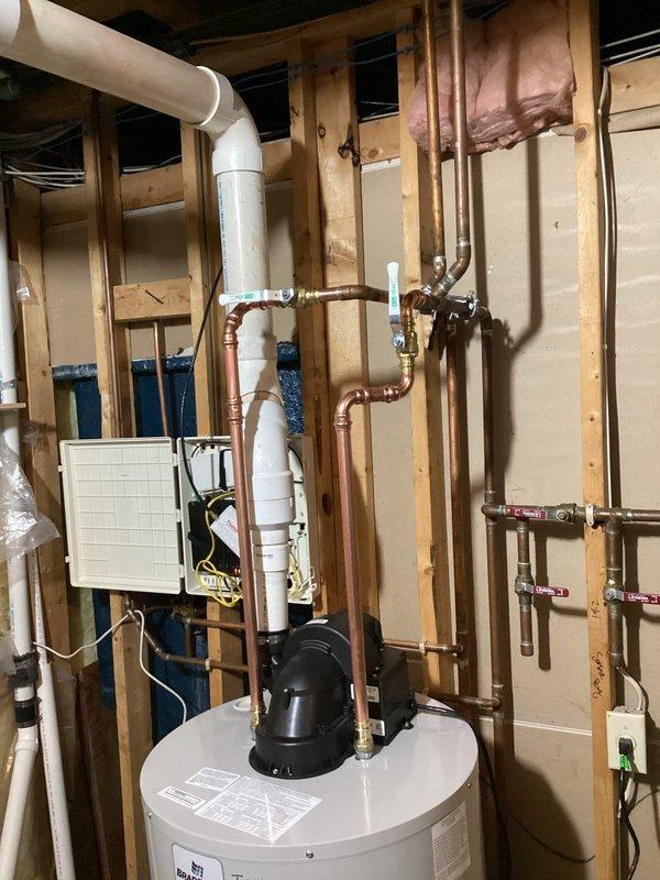 Responded to service call for leaking gas-fired 50-gallon Bradford White tanked water heater located in basement. Upon inspection, confirmed active leak from existing unit positioned on elevated stand. Assessed system configuration including existing copper supply lines, flexible connectors, gas supply, and venting arrangement. Documented equipment condition and surrounding plumbing infrastructure. Provided replacement quote for new water heater installation. Pulled necessary permit for replacement work. Unit requires complete removal and replacement due to tank failure.