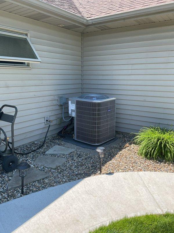 Completed full HVAC system replacement including removal and recycling of existing equipment. Installed new Carrier Comfort Series 26SCA442N003 single-stage air conditioner, Carrier CVAVA4821XMA evaporator coil, and Carrier Performance 97 Series 59TP7A100V21-20 two-stage gas furnace in interior utility space. Positioned outdoor condenser unit on new 2-inch PVC pad with pea gravel base at exterior corner of residence. Installed new electrical disconnect box and whip for outdoor unit. Reconnected system to existing supply and return ductwork. Flushed, pressure tested, and reconnected to existing refrigerant line set to ensure proper refrigerant flow and system integrity. Applied floor protection during installation and performed complete cleanup of work areas. Registered all equipment warranties with manufacturer. Provided system operation overview covering thermostat controls, maintenance requirements, and optimal performance settings. Submitted utility rebate paperwork on behalf of cus