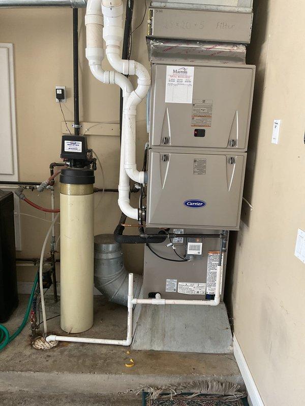 Completed full HVAC system replacement including removal and recycling of existing equipment. Installed new Carrier Comfort Series 26SCA442N003 single-stage air conditioner, Carrier CVAVA4821XMA evaporator coil, and Carrier Performance 97 Series 59TP7A100V21-20 two-stage gas furnace in interior utility space. Positioned outdoor condenser unit on new 2-inch PVC pad with pea gravel base at exterior corner of residence. Installed new electrical disconnect box and whip for outdoor unit. Reconnected system to existing supply and return ductwork. Flushed, pressure tested, and reconnected to existing refrigerant line set to ensure proper refrigerant flow and system integrity. Applied floor protection during installation and performed complete cleanup of work areas. Registered all equipment warranties with manufacturer. Provided system operation overview covering thermostat controls, maintenance requirements, and optimal performance settings. Submitted utility rebate paperwork on behalf of cus