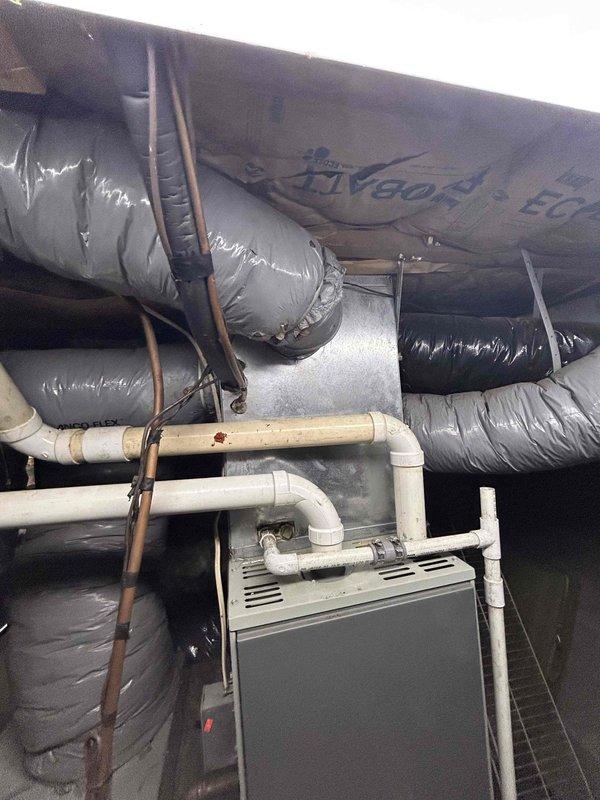Responded to no cooling complaint on heat pump system. Upon inspection, evaluated existing outdoor XL 15i heat pump unit and indoor furnace system approximately 3 years old. Documented current equipment configuration including ductwork, refrigerant lines, condensate drainage system, and electrical connections. Assessed system performance and identified need for heat pump replacement. Provided comprehensive estimate for replacement of outdoor heat pump unit while retaining existing furnace equipment. Photographed existing installation showing indoor air handler with associated PVC drainage piping, copper refrigerant lines, insulated ductwork, and outdoor condenser unit with specification label for customer records and replacement planning purposes.