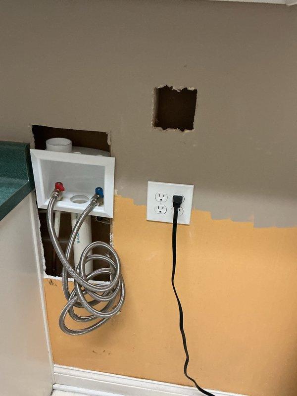 Relocated electrical receptacles to lower position behind washer and dryer area. Opened wall cavity to access existing wiring, installed new outlet boxes at reduced height for improved appliance accessibility, and patched drywall around plumbing chase containing water supply valves. Verified proper GFCI protection and confirmed all connections met current electrical code requirements.