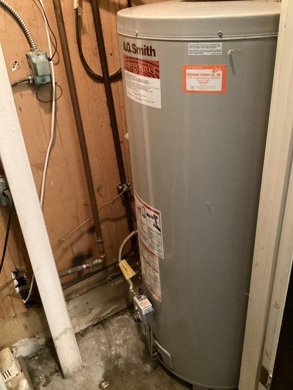 Responded to service call for leaking gas tanked water heater located in interior closet. Upon arrival, inspected A.O. Smith brand gas water heater and associated plumbing connections. Identified active leak at base of unit with visible water damage and staining on concrete floor surrounding tank. Evaluated copper supply lines, brass shut-off valves, and vent flue system for proper installation and functionality. Documented condition of unit, plumbing connections, electrical junction box, and venting configuration through photographic evidence. Based on age of unit, extent of tank corrosion, and severity of leak, recommended full water heater replacement as repair would not be cost-effective or reliable long-term solution.