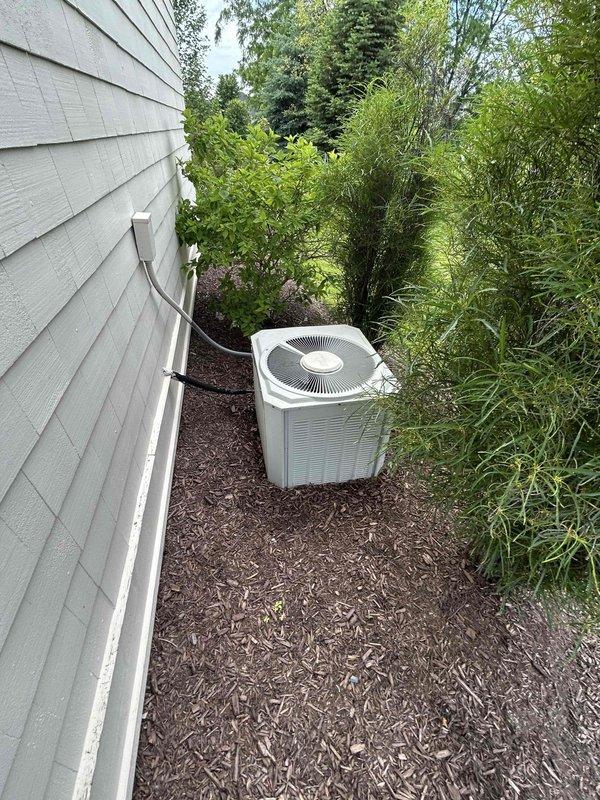 Conducted comprehensive site evaluation for dual HVAC system replacement estimate at residential property. Assessed existing outdoor condenser unit located in narrow side yard with vegetation encroachment and evaluated indoor Trane XE 90 furnace installation in utility closet, including existing PVC venting configuration and electrical connections. Documented current equipment conditions, clearance requirements, and access limitations to provide accurate replacement specifications for both heating and cooling systems.