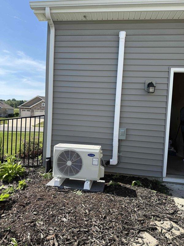 Installed a single-zone Carrier ductless mini-split heat pump system consisting of one CE37MAHAQ12AA3 12,000 BTU outdoor unit with R454B refrigerant and one CE45MAHAQ12XA3 12,000 BTU indoor wall-mounted air handler. Mounted the outdoor condenser on a PVC pad with risers on the exterior of the residence and installed the indoor head unit on an interior wall. Ran new refrigerant line sets between the indoor and outdoor units, installed control wiring for communication between components, and established condensate drain lines with PVC piping routed along the exterior siding. Completed all startup procedures, verified proper system operation, and confirmed cooling and heating functionality.