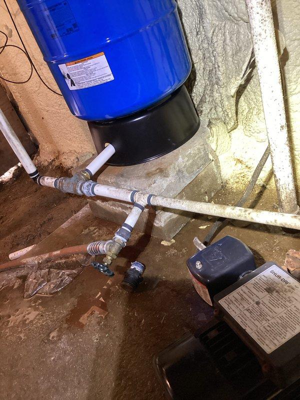 Responded to water leak on well water line in basement. Located leak at pipe penetration through spray foam insulation near pressure tank and well system piping. Assessed PVC plumbing configuration and identified dripping connection point in copper supply line. Tightened fitting connections and verified leak repair, confirming well pump cycle returned to normal operation without continuous running.