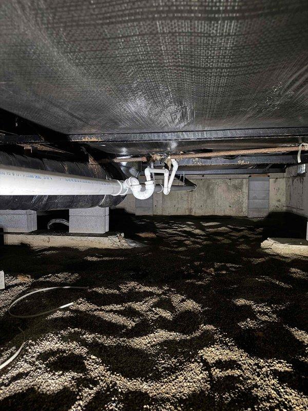 Successfully tied AC condensate drain line into the existing 3" main drain system in the crawl space. Installed white PVC piping with proper P-trap configuration to ensure adequate drainage and prevent airflow issues. All connections were secured and tested to verify proper operation and compliance with plumbing codes.