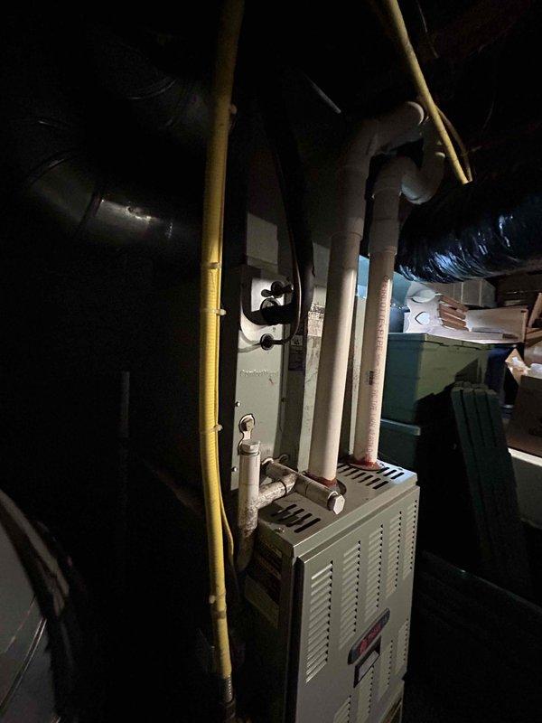 Tech lead Dennis completed an HVAC equipment replacement estimate in a mechanical utility space. Comprehensive measurements and documentation were taken of the existing furnace/air handler unit and associated piping systems, including PVC drainage lines and gas supply connections, to prepare specifications for a complete system replacement.