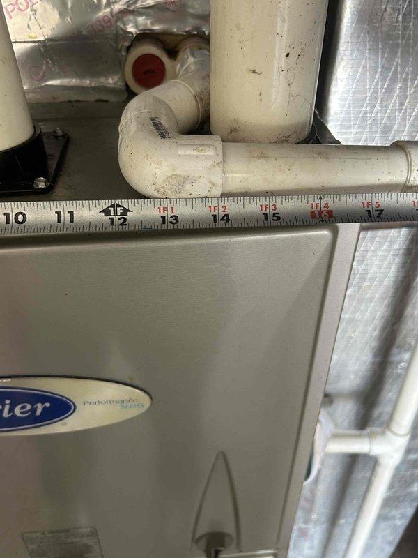Performed counter sales consultation and provided technical guidance for HVAC system installation. Documented existing Carrier HVAC equipment configuration including stacked unit positioning, PVC condensate drain line routing with measurements, and mechanical space layout with reflective insulation barriers. Captured reference photos showing pipe dimensions, clearances, and component accessibility for planning purposes.