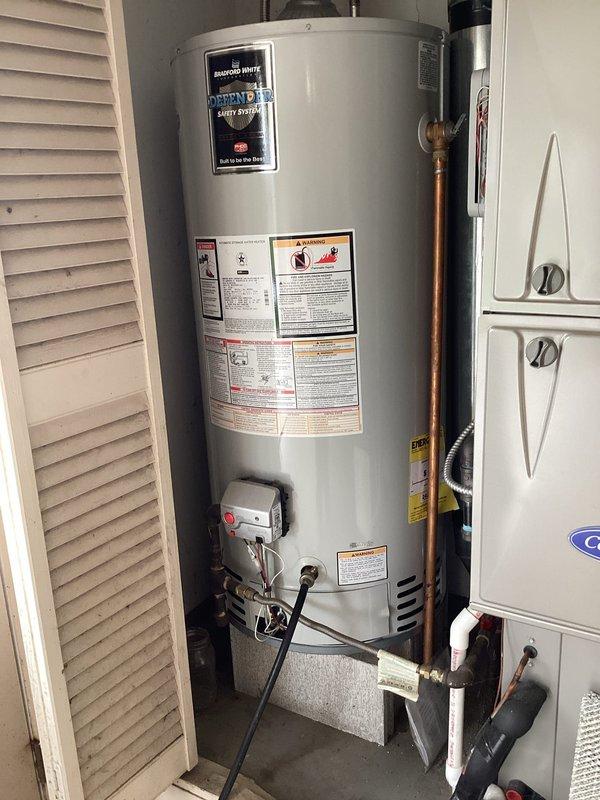 Performed complete maintenance flush on 40-gallon Bradford White tanked gas water heater located in garage utility closet. Drained sediment buildup from tank, inspected temperature and pressure relief valve, verified proper operation of gas control valve and burner assembly, checked all copper water line connections and shutoff valves for leaks, and refilled unit to restore hot water service. All components found functioning within normal parameters upon completion of routine maintenance service.