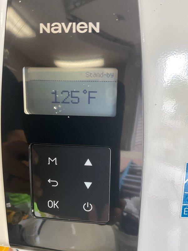 Successfully installed a Navien NPE-240A2 natural gas tankless water heater in the lower level, replacing the existing conventional water heater in the same location. The unit was accessed through outdoor lower level entry, requiring a two-person crew for safe removal of the old equipment and installation of the new tankless system. 

During the installation process, addressed a water leak originating from an outdoor faucet that was penetrating into the basement area. Cut open the interior wall to access and repair the leak source, keeping the opening minimal per customer request to allow for future access panel installation. Completed all necessary plumbing connections, gas line hookup, venting, and electrical requirements for the tankless unit. System was tested, calibrated to 125°F operating temperature, and confirmed in proper stand-by mode with all controls functioning correctly.