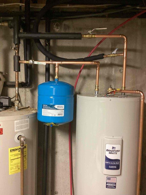 Installed a new 50-gallon Bradford White electric water heater to replace existing unit, including all necessary copper piping connections, pressure relief valve, and shut-off valves. Integrated a whole house water filtration system with blue pressure tank into the main water supply line, utilizing PVC and copper pipe connections with appropriate fittings and isolation valves. Completed all electrical connections to code and tested system for proper operation and leak-free performance.