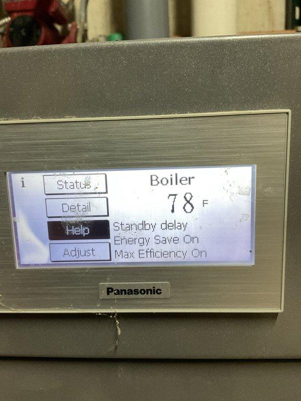 Responded to no hot water complaint on combination boiler system providing both space heating and domestic hot water. Upon arrival, found Panasonic digital control panel displaying standby mode with energy-saving features activated. Previous technician had addressed drain line obstruction during recent service call. Inspected hydronic heating system including manifold assembly with multiple zone valves, expansion tank, and copper distribution piping. Verified all shut-off valves, brass fittings, and PVC condensate drain lines for proper operation. Cleared blockage from drain pipe as recommended by heating technician from prior visit. Cycled system through operating modes and confirmed restoration of domestic hot water production. System returned to normal operation with proper temperature output.