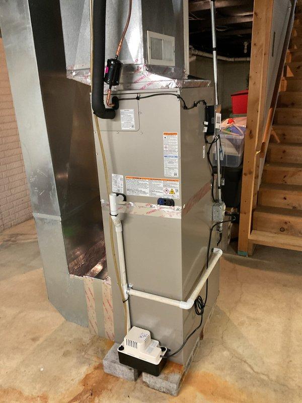 Completed full HVAC system installation in basement mechanical room, including Carrier 59TP7A080V17-16 Performance 97 Series two-stage gas furnace with 97% AFUE rating, Carrier 26SCA436N003 Comfort Series single-stage 3-ton air conditioner, and Carrier CVAVA4217XMA evaporator coil. Installed Honeywell FocusPro thermostat for system control and integrated Honeywell 4-inch media air cleaner for enhanced filtration. Reconnected existing supply and return ductwork to new equipment, installed new electrical disconnect and whip for outdoor unit, and completed all refrigerant line connections with proper insulation. Mounted furnace on concrete blocks with condensate pump for proper drainage, ran PVC condensate drain lines vertically through ceiling joists, and verified all electrical connections meet code requirements. Tested two-stage furnace operation, confirmed proper airflow across evaporator coil, and verified refrigerant charge on air conditioning system. Explained system operation to h