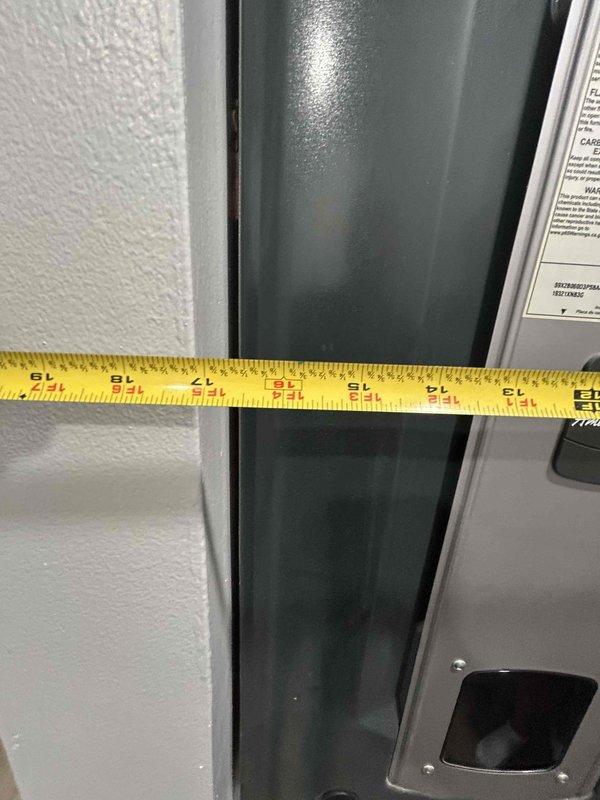Conducted HVAC system evaluation for equipment replacement estimate. Documented existing Honeywell digital thermostat displaying 75 degrees and measured ductwork dimensions at approximately 22-24 inches for proper sizing calculations. Photographed current equipment configuration including cylindrical duct components and cabinet housing to assess replacement requirements and ensure accurate specifications for new system installation.