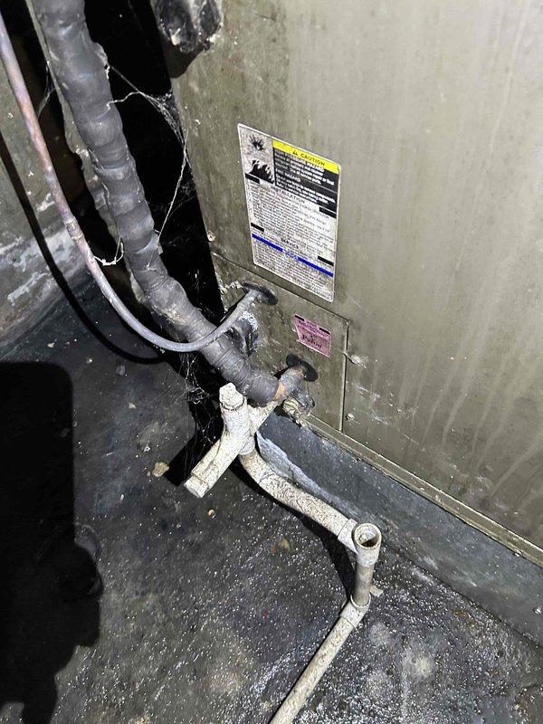 Completed comprehensive HVAC system replacement estimate assessment. Documented existing Carrier air handler unit and associated equipment showing significant age-related wear, dust accumulation, and operational deterioration. Evaluated current system configuration including ductwork connections, refrigerant lines with degraded insulation, condensate drain piping, electrical conduit, and control components to determine replacement specifications and scope of work required for full system upgrade.
