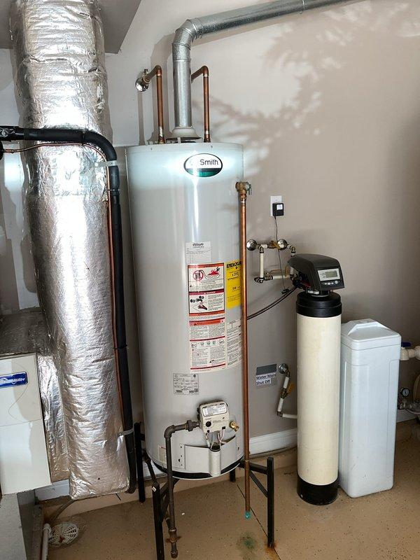 Provided estimate for replacement of existing 50-gallon A.O. Smith natural gas water heater located in garage. Current unit manufactured in April 2012 is operational but aging, and homeowner is planning for proactive replacement. Documented existing installation including water heater mounted on stand with copper supply connections, proximity to water softener system, and proper venting configuration.