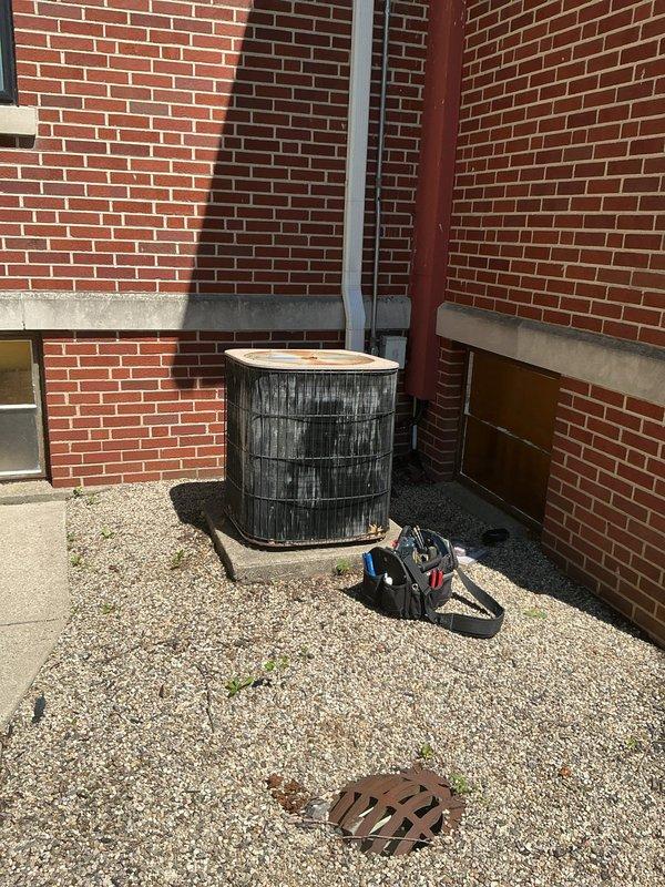 Responded to no cooling call for library unit. Upon arrival, confirmed rooftop HVAC unit was not operating. Inspected 10+ year old package unit located on roof with gravel surface. Diagnosed complete system failure - unit would not energize. Checked electrical connections, verified thermostat communication, and assessed overall system condition. Unit showed significant age-related wear and weathering on exterior casing. Documented equipment location and condition with photos for customer records.