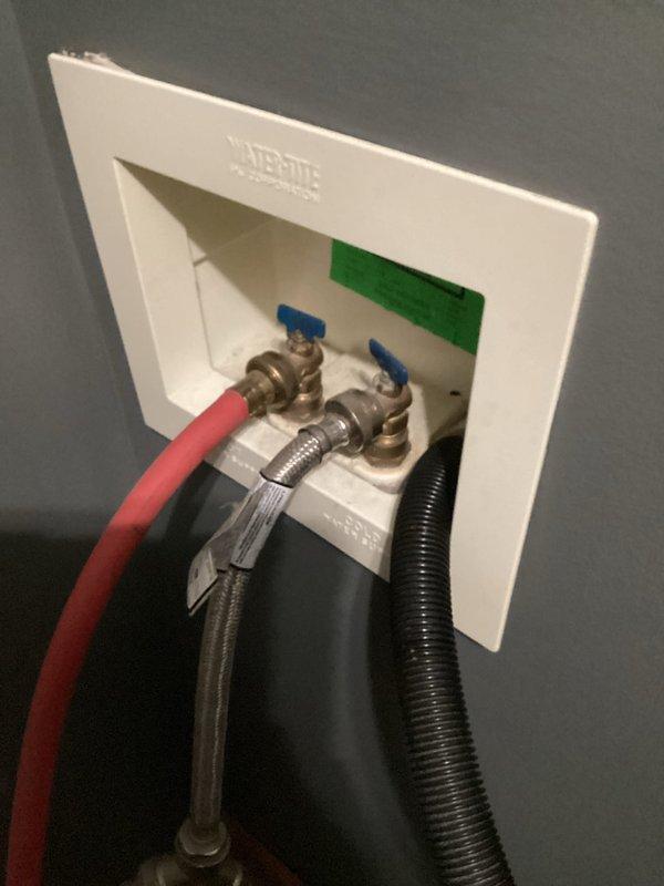 Responded to service call for washing machine installation issue where water supply could not be shut off. Successfully replaced or repaired malfunctioning shut-off valves in recessed Waterite wall box, installing new brass ball valves with blue handles to control hot and cold water lines. Verified proper operation of both valves, ensuring complete water shut-off capability for safe appliance installation and future maintenance access.
