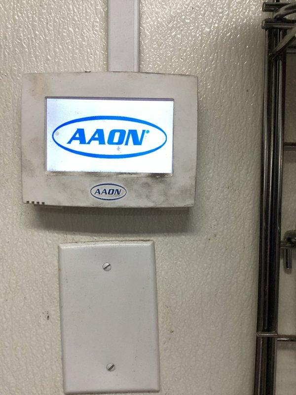 Responded to no-power condition on AAON kitchen unit. Upon arrival, confirmed unit was completely non-responsive with no display activity at wall-mounted control panel. Inspected control board and identified failed circuit board component preventing system operation. Documented existing circuit board condition showing barcode 2280103 and component markings. Unit required control board replacement to restore functionality.