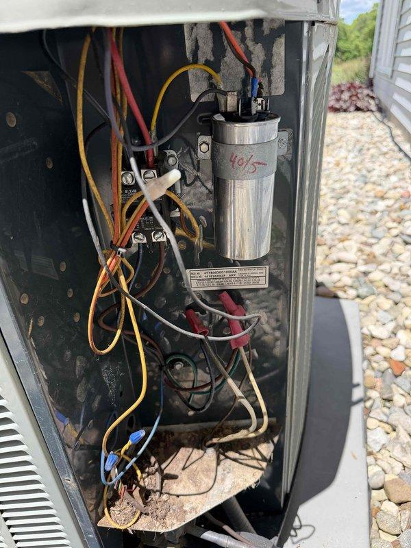 Completed routine cooling system maintenance for monthly member. Accessed outdoor condensing unit and inspected electrical components including capacitor, contactors, and wiring connections. Removed significant accumulation of dried grass, plant material, and debris from interior compartment and base of unit that had built up from outdoor exposure. Performed electrical testing with multimeter probes to verify proper voltage and component operation. Cleaned debris from concrete pad surrounding unit. All electrical connections secure, components operating within normal parameters. System running efficiently following maintenance and cleaning procedures.