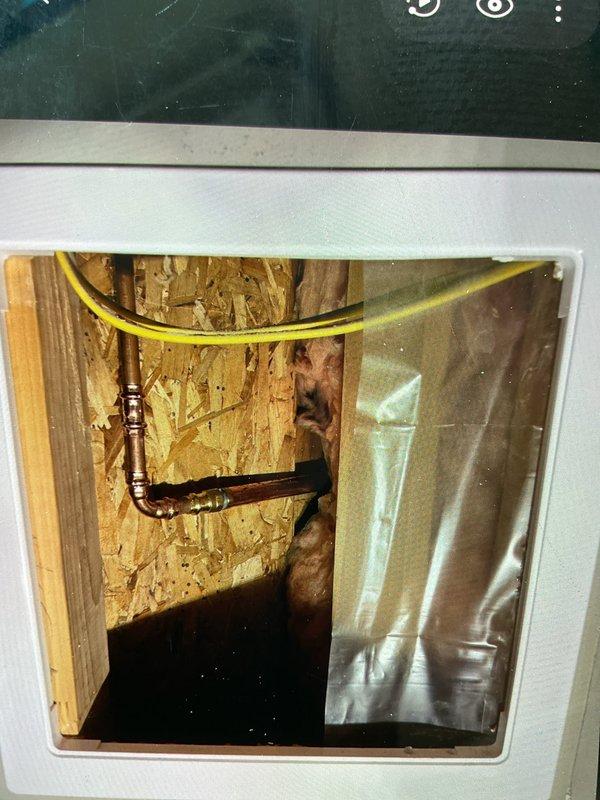 Responded to report of leak originating from outdoor faucet and running into basement. Cut access opening in wall to locate and diagnose source of water intrusion, keeping opening minimized per customer request to allow for future access panel installation. Accessed wall cavity revealing copper supply line with deteriorated fittings causing the leak. Removed and replaced defective outdoor faucet assembly including threaded brass fittings and copper connections. Tested system for proper operation and verified no additional leaks present. Left access opening available for installation of permanent access panel for future maintenance.