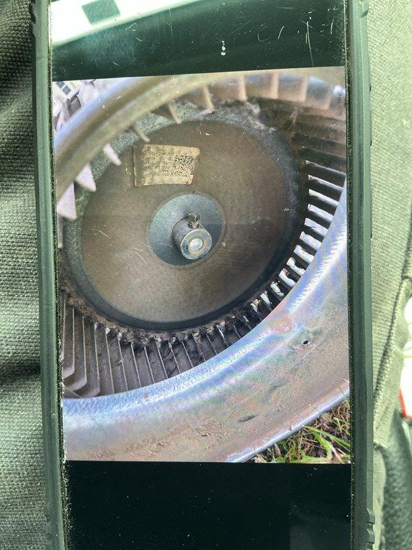 Responded to service call regarding water leaking from light fixture below attic-mounted gas furnace. Upon inspection, discovered condensate drain system blockage causing water overflow from the air handler unit. Inspected blower assembly and confirmed excessive moisture accumulation around blower wheel and housing, with visible water pooling in drain pan. Cleared condensate drain line obstruction, verified proper drainage flow, and confirmed no further leaking. System tested and returned to normal operation.
