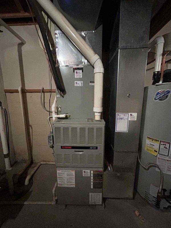 Completed comprehensive estimate for full HVAC system replacement including both furnace and air conditioning units. Assessed existing Trane furnace located in basement utility area along with current air conditioning system, documented equipment specifications, ductwork configuration, and installation requirements. Photographed existing equipment including furnace with PVC condensate drainage, metallic ductwork plenum, and associated mechanical components to provide accurate replacement pricing and system specifications for complete system changeout.