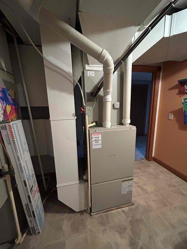 Completed comprehensive estimate for full HVAC system replacement including furnace and air conditioning unit, both originally installed in 2003 and reaching end of service life. Assessed existing basement-installed furnace with overhead ductwork and evaluated airflow deficiency to master bedroom. Documented current equipment specifications including model KGGRC 120C-20C unit and photographed existing duct configuration to provide replacement options addressing inadequate air distribution to primary living areas.