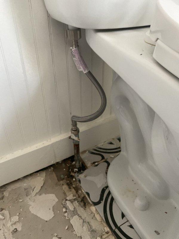Responded to water loss emergency to repair failed toilet supply line. Upon arrival, discovered braided flexible supply line had failed at wall connection point, causing significant water damage to bathroom flooring and substrate. Removed damaged supply line and installed new braided stainless steel flexible connector with proper compression fittings. Secured all connections and pressure-tested system to verify no leaks. Documented extensive floor deterioration around toilet base and water damage to underlayment materials. All plumbing connections restored to proper working order and system returned to service.