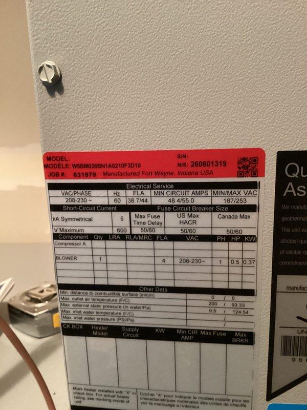 Completed installation of geothermal heat pump system with associated mechanical equipment. Installed Rheem MODEL W6B003BBN1A0210F3D10 geothermal unit with electrical service rated at 208-230V, 60Hz, requiring 36.7/44 circuit amperage and 43/46.5 minimum circuit amps. Unit manufactured in Fort Wayne, Indiana, serial number 260601319, job number 831879. Mounted and secured main heat pump unit to wall with proper specification labeling affixed for future reference and compliance documentation.

Installed complete domestic hot water system integration including Rheem electric water heater with expansion tank assembly. Mounted blue pressure/expansion tank to wall with proper support and connected via copper piping with brass fittings and compression connections. Ran copper supply and return lines from geothermal unit to water heater with appropriate shut-off valves at key connection points. Installed black flexible connector hose between plumbing manifold and water heater inlet. Connected 