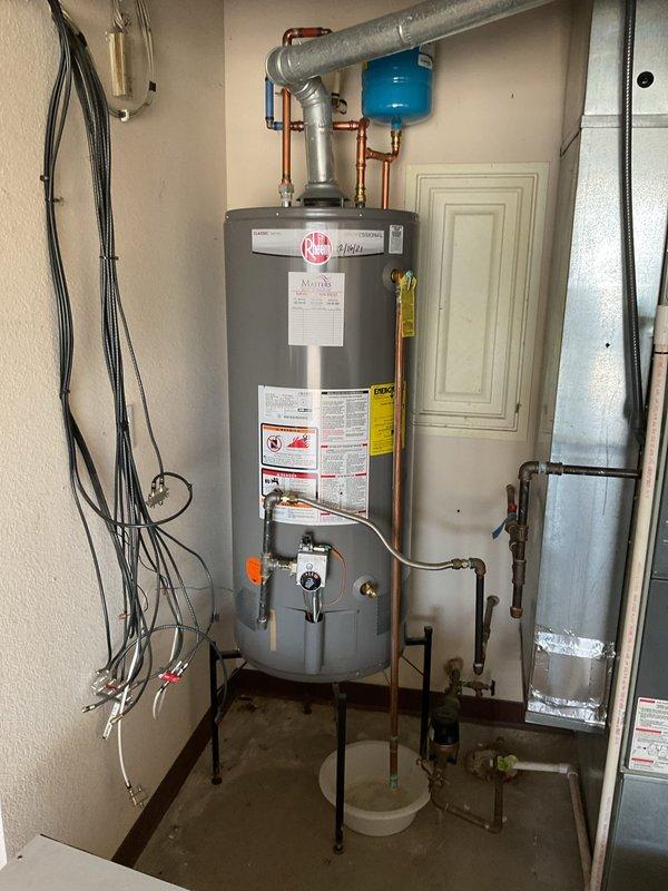 Completed preventive maintenance on Rheem tanked water heater located in garage utility room. Performed standard water heater flush procedure to remove sediment buildup from tank bottom, inspected all copper supply and discharge piping connections, verified proper operation of temperature and pressure relief valve, and examined expansion tank mounting and pressurization. Checked burner assembly access panel, confirmed pilot light operation through viewing window, and inspected venting system integrity. All plumbing connections, shut-off valves, and support legs found secure with no visible leaks or corrosion. Unit operating within normal parameters upon completion.
