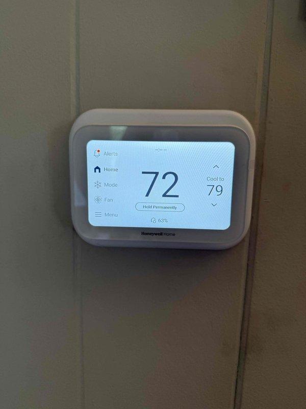 Completed full HVAC system installation including Carrier 26SCA424N003 Comfort Series single-stage air conditioner (2-ton), Carrier CVAVA3017XMA evaporator coil, and Carrier 59TP7A060V17-16 Performance 97 Series two-stage gas furnace with 97% AFUE rating. Removed and recycled existing equipment, then installed new furnace with #2 installation kit for 80-90 efficiency upgrade. Reconnected to existing line set after performing complete flush and pressure test to ensure system integrity. Installed Honeywell 4" media air cleaner for improved indoor air quality and mounted new 2" PVC condenser pad with pea gravel base for outdoor unit stability. Set up Honeywell Elite Pro S1200 programmable thermostat, programmed system parameters, and provided comprehensive operation explanation to homeowner. Reconnected all existing supply and return ductwork, verified proper airflow throughout system, and submitted utility rebate paperwork. Applied floor protection throughout work areas and completed tho