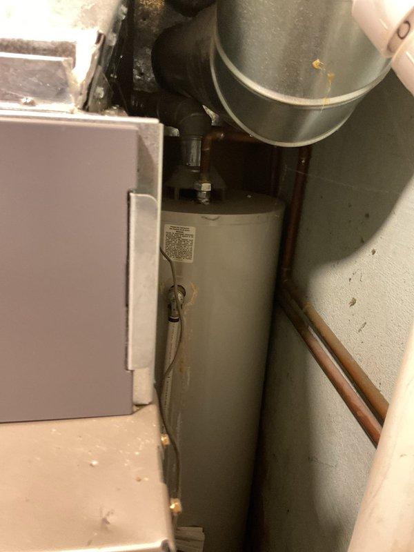 Provided estimate for replacement of existing 40-gallon gas-fired Bradford White Defender water heater located on main floor in confined space behind furnace. Evaluated tight working conditions, existing copper plumbing connections, galvanized metal venting system, and pressure relief valve configuration to determine scope of replacement work and access requirements.