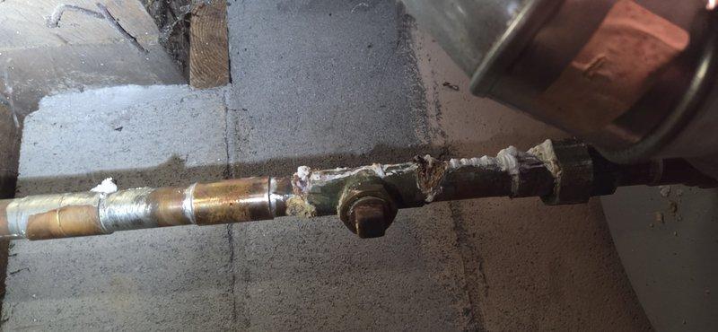 Responded to report of suspected water heater leak in basement. Upon inspection, determined the actual source was condensate drainage from the HVAC system rather than the water heater. Inspected furnace/AC condensate line and identified issues with the drainage system. Photographed corroded copper piping showing significant oxidation and deterioration at connection points, along with the condensate drain configuration in the crawl space area. Advised customer of findings and coordinated follow-up appointment for proper repair of the condensate drainage system.