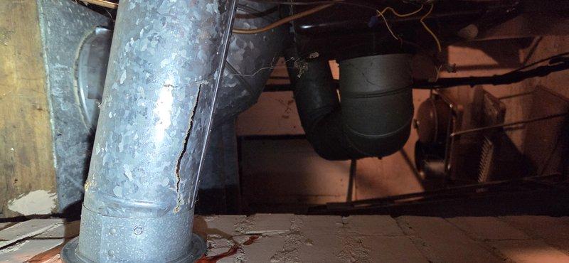 Responded to report of suspected water heater leak in basement. Upon inspection, determined the actual source was condensate drainage from the HVAC system rather than the water heater. Inspected furnace/AC condensate line and identified issues with the drainage system. Photographed corroded copper piping showing significant oxidation and deterioration at connection points, along with the condensate drain configuration in the crawl space area. Advised customer of findings and coordinated follow-up appointment for proper repair of the condensate drainage system.