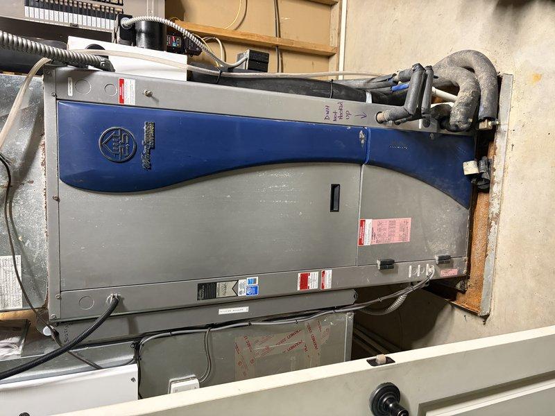 # HVAC Service Call - No Cooling Issue

Responded to a no cooling complaint on an aging air handler system over 10 years old. Upon arrival, performed comprehensive diagnostic evaluation of the unit installed in the basement mechanical room. Inspected the gray metal air handling unit with integrated control panel and associated ductwork connections. 

Examined all electrical components including the white control panel housing with mounted pumps and motors. Verified proper voltage and amperage readings at the unit. Tested thermostat communication and control signals to ensure proper system operation. Inspected refrigerant line connections, including the gray insulated piping running to the unit, checking for proper insulation integrity and signs of refrigerant leakage.

Evaluated the condition of flexible metal ductwork and rigid duct connections for proper airflow. Checked condensate drainage system for blockages or improper drainage that could affect system performance. Inspected all 
