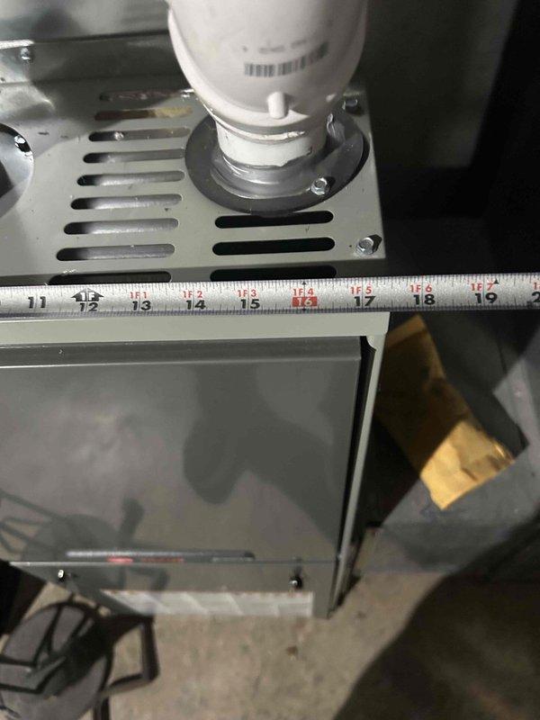 Tech lead Dennis conducted an HVAC system evaluation for equipment replacement in a basement mechanical room. Assessment included a Trane furnace unit with dual PVC vent pipes, measuring existing equipment dimensions and documenting current installation configuration. Comprehensive photographic documentation was completed to support replacement estimate specifications and ensure proper sizing for new equipment installation.