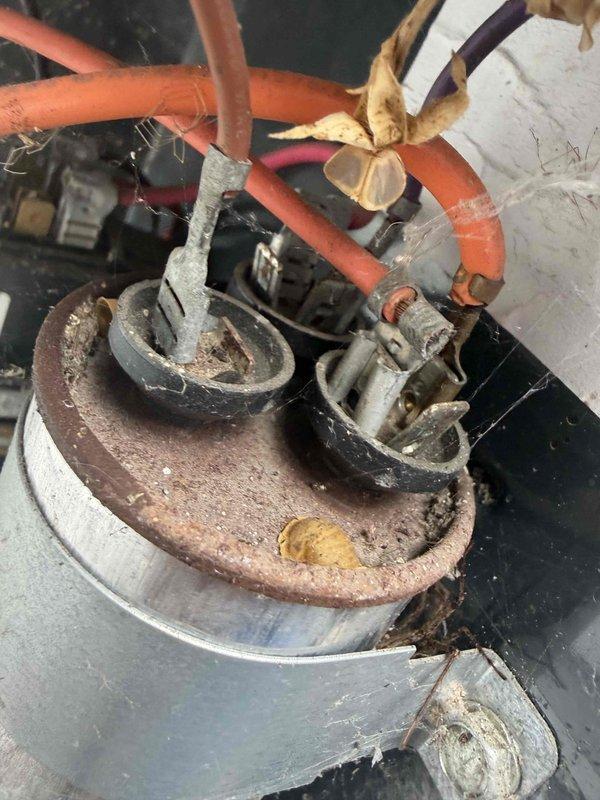 Completed first cooling season maintenance visit on residential HVAC system. Inspection revealed significant corrosion and rust on electrical connections and motor assembly components, with heavy oxidation present on mounting brackets and U-shaped electrical connectors. Documented existing 16x25x4 air filter in housing unit with installation date marked as September 24, 2019, indicating filter is well beyond recommended replacement interval and requires immediate replacement for optimal system performance and air quality.