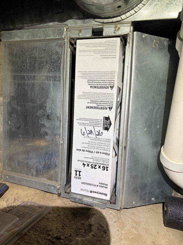 Completed first cooling season maintenance visit on residential HVAC system. Inspection revealed significant corrosion and rust on electrical connections and motor assembly components, with heavy oxidation present on mounting brackets and U-shaped electrical connectors. Documented existing 16x25x4 air filter in housing unit with installation date marked as September 24, 2019, indicating filter is well beyond recommended replacement interval and requires immediate replacement for optimal system performance and air quality.