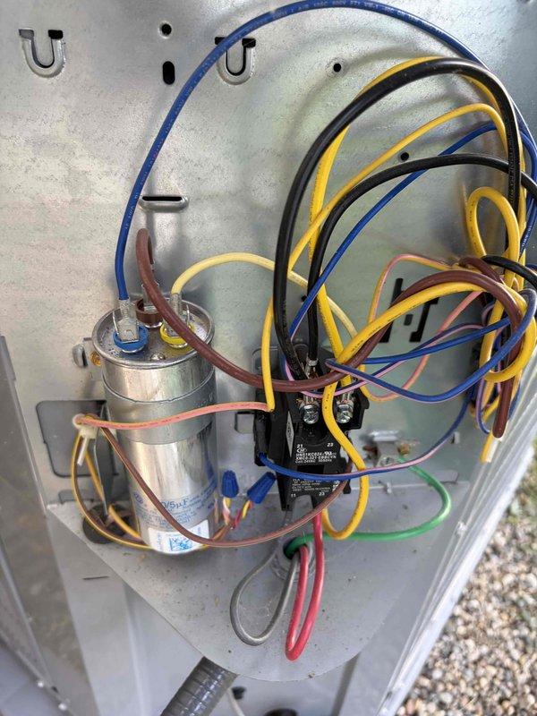Completed routine cooling system maintenance inspection on residential HVAC unit. Inspected dual-run capacitor rated at 40/5µF 440VAC, verified proper electrical connections and wire terminations with secure wire nut connections. Examined compressor unit, confirmed all electrical wiring connections intact including proper routing of power and control wiring. All components operating within normal parameters with no issues identified during inspection.