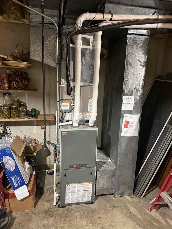 Successfully completed full HVAC system installation including a Carrier Comfort Series 27SCA530A003 single-stage heat pump outdoor unit, Carrier CVAVA3617XMA evaporator coil, and Honeywell ELITEPRO S1200 thermostat. Removed and recycled existing equipment from basement utility area, reconnected to existing line set after flushing and pressure testing to ensure proper refrigerant flow and system integrity. Installed new 2-inch PVC condenser pad with pea gravel base in exterior corner location, positioning unit on elevated rubber mounting pad with proper clearances for airflow and service access. Ran new low voltage wiring from indoor air handler to outdoor heat pump unit to accommodate heat pump operation and reversing valve control. Installed new electrical disconnect and whip at outdoor unit per code requirements. Reconnected existing supply and return ductwork to new evaporator coil, ensuring proper airflow and sealed connections. Performed system startup, verified proper refrigeran