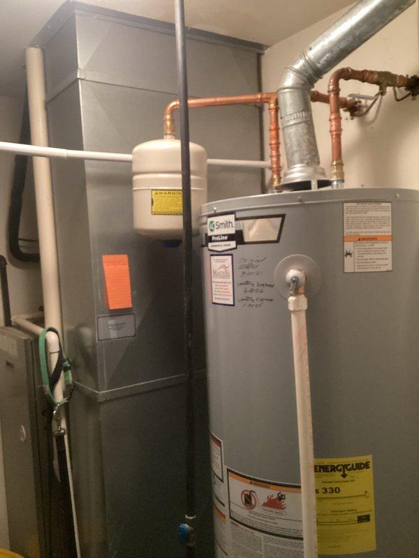 Responded to report of water leaking from valve at top of recently installed water heater. Upon inspection, identified active leak at temperature and pressure relief valve connected to white discharge pipe on Smith brand water heater installed in May 2021. Assessed T&P valve operation and discharge piping configuration. Documented equipment conditions and leak source with photographs for service records.