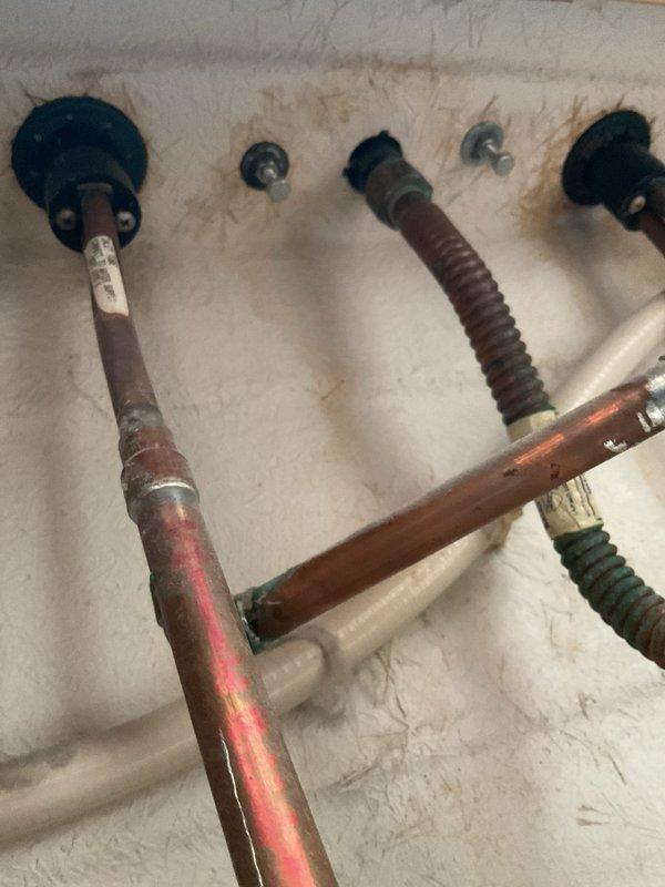 Responded to service call for leaking faucet on Jacuzzi whirlpool bathtub. Upon inspection, identified corroded copper supply lines with visible oxidation and aging flexible supply hoses requiring attention. Assessed plumbing connections mounted to wall, noting deteriorated condition of piping system with multiple connection points showing signs of wear. Also evaluated kitchen sink per customer request for potential future replacement needs.