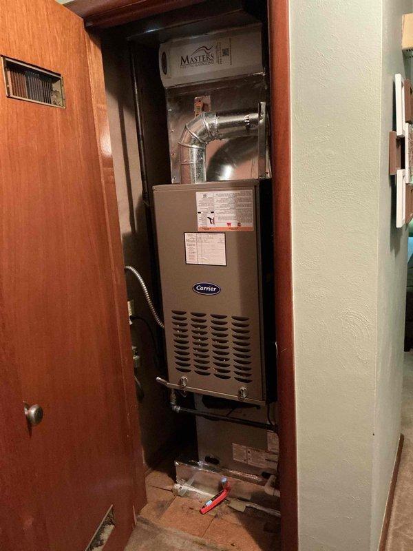 Completed prepaid cooling maintenance on Carrier furnace system with Masters air handler installed in closet utility space. Performed standard seasonal inspection including filter check, airflow verification, and system operational testing. Unit found in good working condition with all safety labels and specifications clearly visible; system responding normally with indicator light showing proper operation.