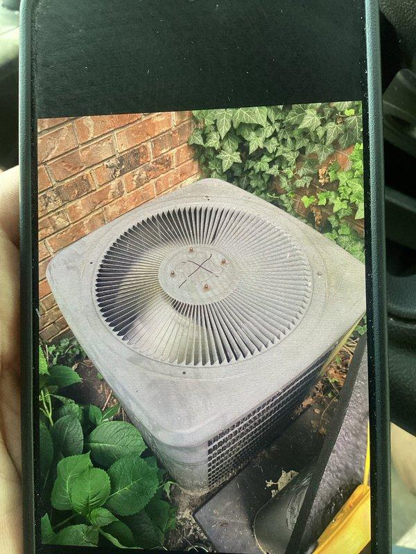 Responded to no cooling call on commercial R22 system over 10 years old. Found heavily clogged air filter restricting airflow to system. Documented existing outdoor condenser unit condition showing age-appropriate wear on beige unit with circular top grille positioned against brick exterior with surrounding vegetation. Replaced dirty filter to restore proper airflow and system operation.