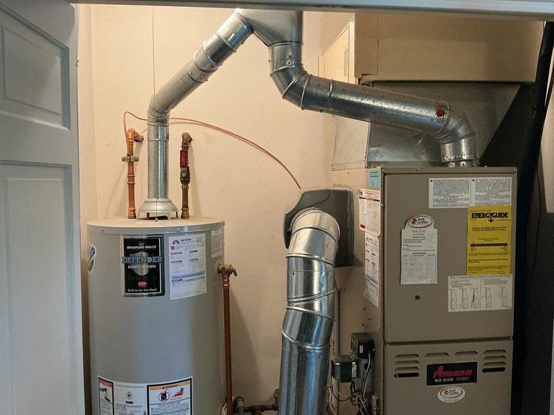 Conducted on-site evaluation of existing HVAC system experiencing performance issues. Assessed current Amana furnace unit and associated ductwork configuration in utility space, taking measurements and documenting equipment specifications. Photographed existing system installation including furnace dimensions, ductwork layout, and utility room clearances to prepare comprehensive replacement estimate for customer's review.