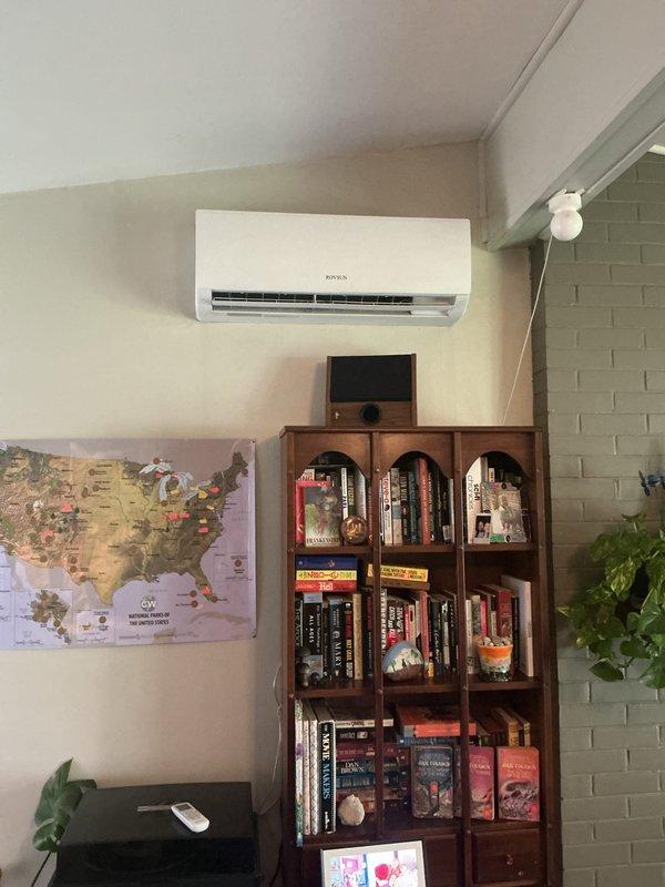Responded to service call for non-cooling Royen brand ductless mini-split system in living room. Assessed indoor wall-mounted evaporator unit and outdoor Rovsun condenser unit, documented existing installation with photos, and provided estimate for complete system replacement due to equipment failure.