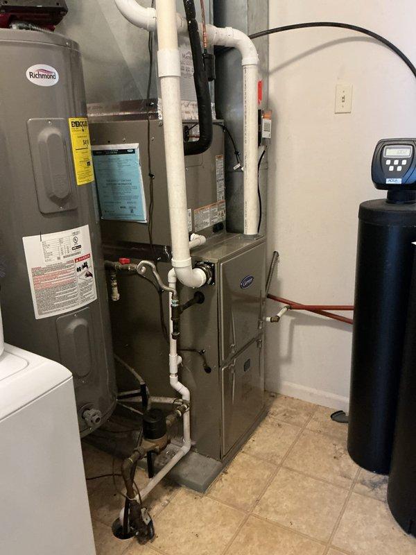 Completed full HVAC system replacement in residential utility room, installing new Carrier Performance 97 Series two-stage gas furnace (model 59TP7A060V17--16), Carrier Comfort Series single-stage air conditioner (model 26SCA424N003), and Carrier evaporator coil (model CVAVA3017XMA). Removed and recycled existing equipment, reconnected to existing line set after flushing and pressure testing, and reconnected all existing supply and return ductwork. Installed new 2" PVC condenser pad with pea gravel base, new disconnect and whip for outdoor unit, and completed furnace changeout with #2 installation kit for 80% to 90% efficiency upgrade. Routed white PVC venting and condensate drainage piping, secured all gas line connections with shutoff valves, and verified proper operation of all system components. Applied floor protection throughout work area and completed thorough cleanup of installation site. Provided comprehensive system operation explanation and thermostat programming instruction