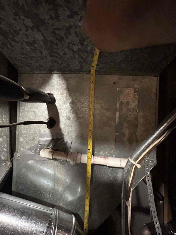 Tech lead conducted comprehensive assessment of existing HVAC system for complete replacement estimate. Documented current furnace installation in basement mechanical room, including measurements of confined equipment space and existing ductwork configuration. Evaluated condition of aging furnace unit, metal supply ductwork with reflective insulation, and associated mechanical components including condensate drainage lines and electrical connections. Photographed equipment access clearances, ceiling-mounted distribution systems, and spatial constraints within utility area to determine proper sizing and installation requirements for replacement system. Assessed existing infrastructure condition including corroded access panels, water staining on metallic surfaces, and overall equipment deterioration to provide accurate replacement specifications and scope of work for complete HVAC system upgrade.