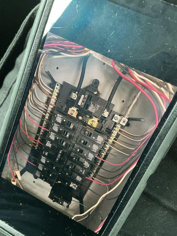 Responded to customer complaint of voltage issues affecting mini split operation and non-functioning receptacles. Performed electrical system inspection, accessing service panel and examining circuit breaker configuration, wiring connections, and receptacle circuits. Documented electrical panel condition showing dual-row breaker arrangement with main disconnect and branch circuits, noting wire routing and connection points. Inspected junction box containing receptacle devices and associated wiring to identify potential causes of reported power issues.
